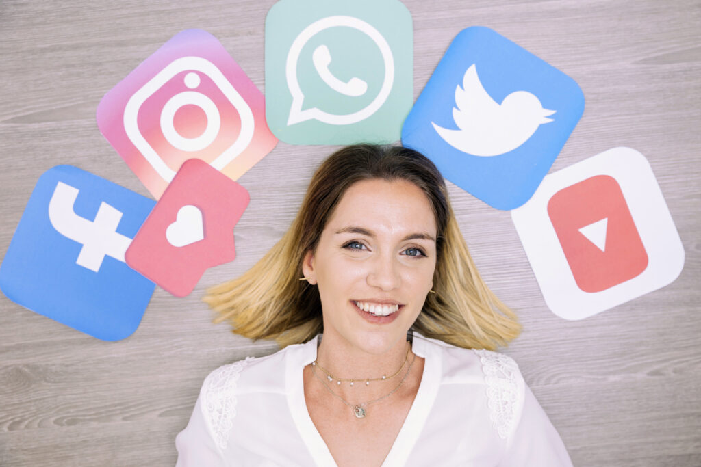 portrait smiling woman standing front wall with social networking icons Creamos estrategias de marketing digital que obtienen resultados palpables para tu negocio.